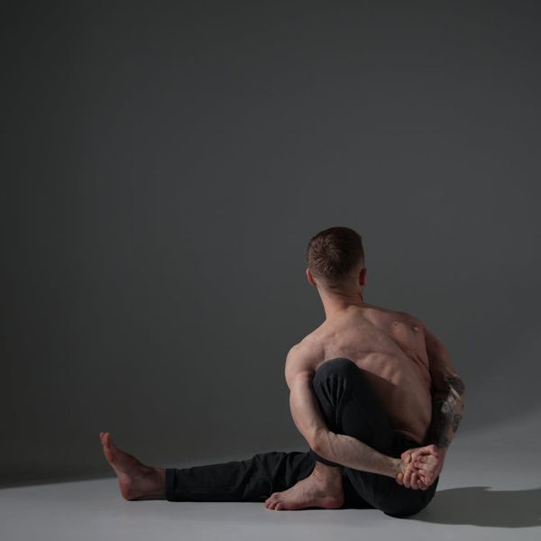 Person in a balancing yoga pose against a serene, dark background.